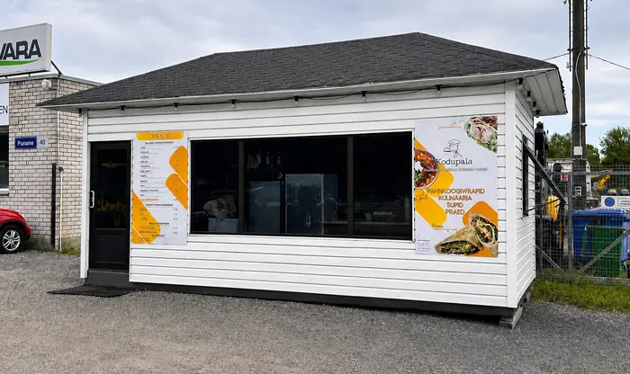 Kodupala Kioski valge kiosk Punane tänaval Tallinnas, fassaadil menüü ja logo